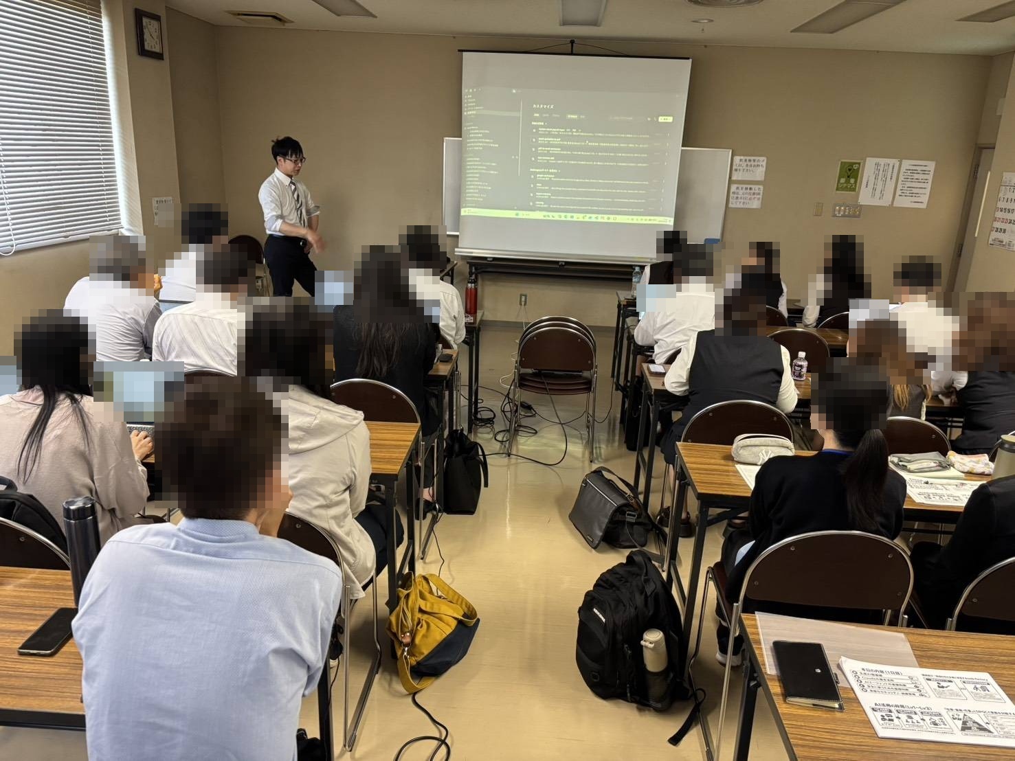 長崎県の企業で行ったClaudeを中心としたAI研修の様子。講師がスクリーンにClaudeの画面を映して説明し、社員のみなさんが受講している